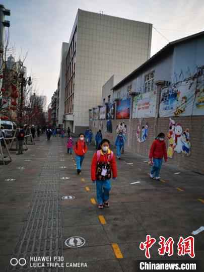 乌鲁木齐市第一小学开学第一天,学生走在校园门口的路上。 梁莉 摄 新疆中小学和中职学校全面开学复课